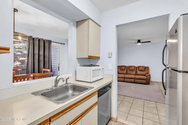 a kitchen with stainless steel appliances granite countertop a sink and a refrigerator