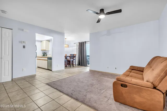 a living room with furniture and kitchen view