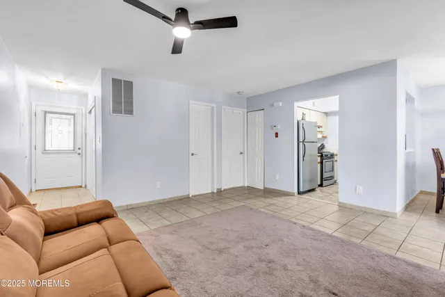 a living room with furniture and a ceiling fan