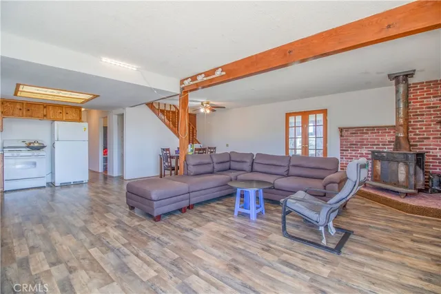 a kitchen with stainless steel appliances granite countertop a refrigerator a sink dishwasher and wooden cabinets with wooden floor