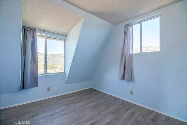 an empty room with wooden floor and a window