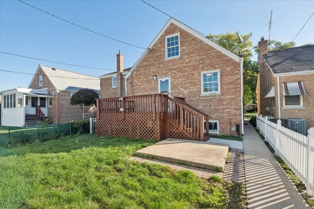 a view of a house with a small yard and wooden fence