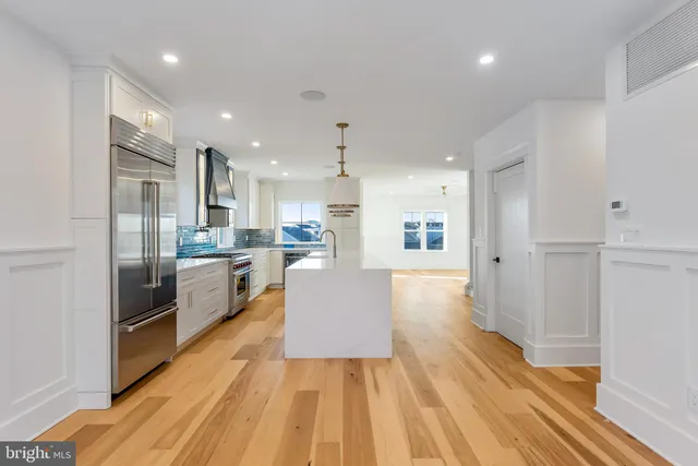 a kitchen with kitchen island granite countertop a sink cabinets and wooden floor