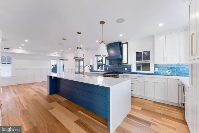 a view of a kitchen with kitchen island a sink stainless steel appliances and cabinets