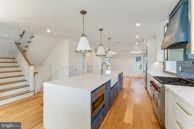 a view of a livingroom with wooden floor and a kitchen