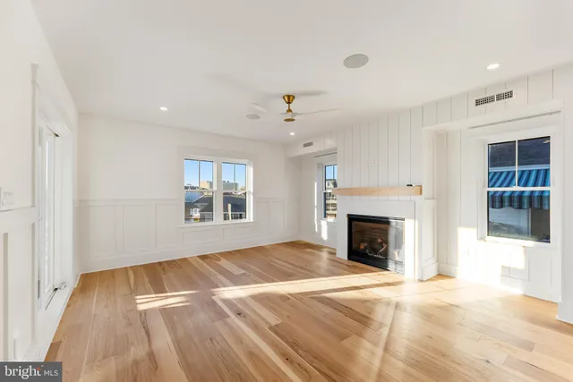 a view of a living room a kitchen with a fireplace wooden floor and kitchen view