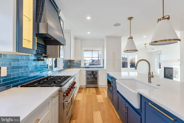 a large kitchen with kitchen island white cabinets and stainless steel appliances