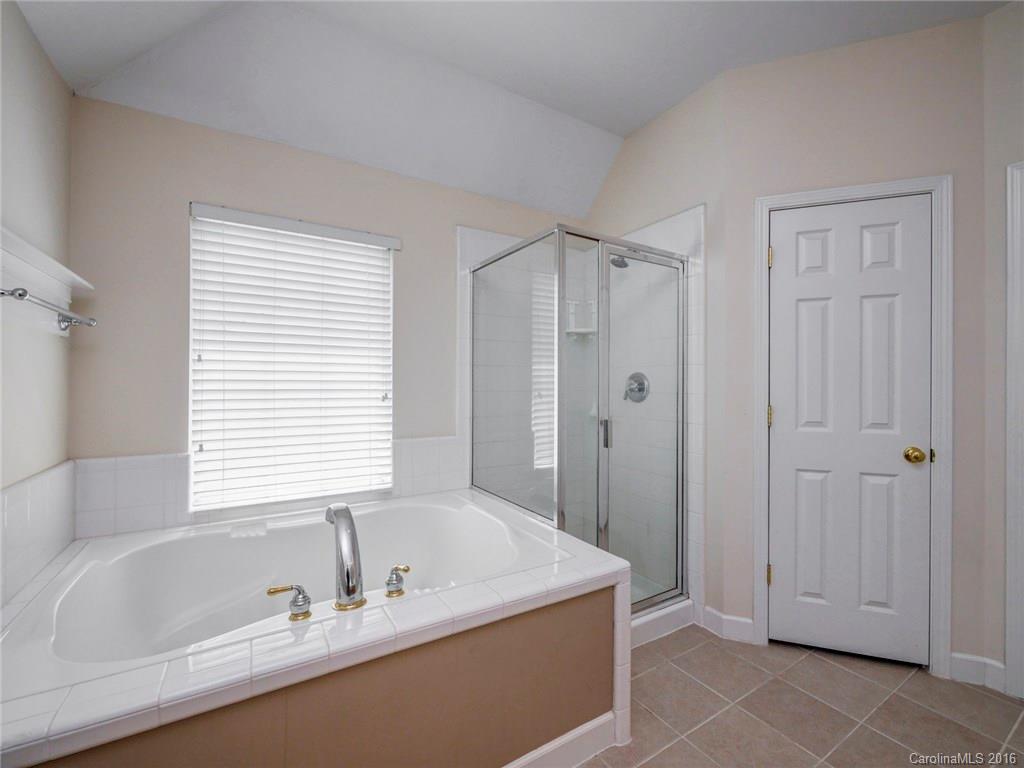 8319 Camberly Road Huntersville, NC 28078 - Photo 16 of 24 a bathroom with a tub a sink and a window