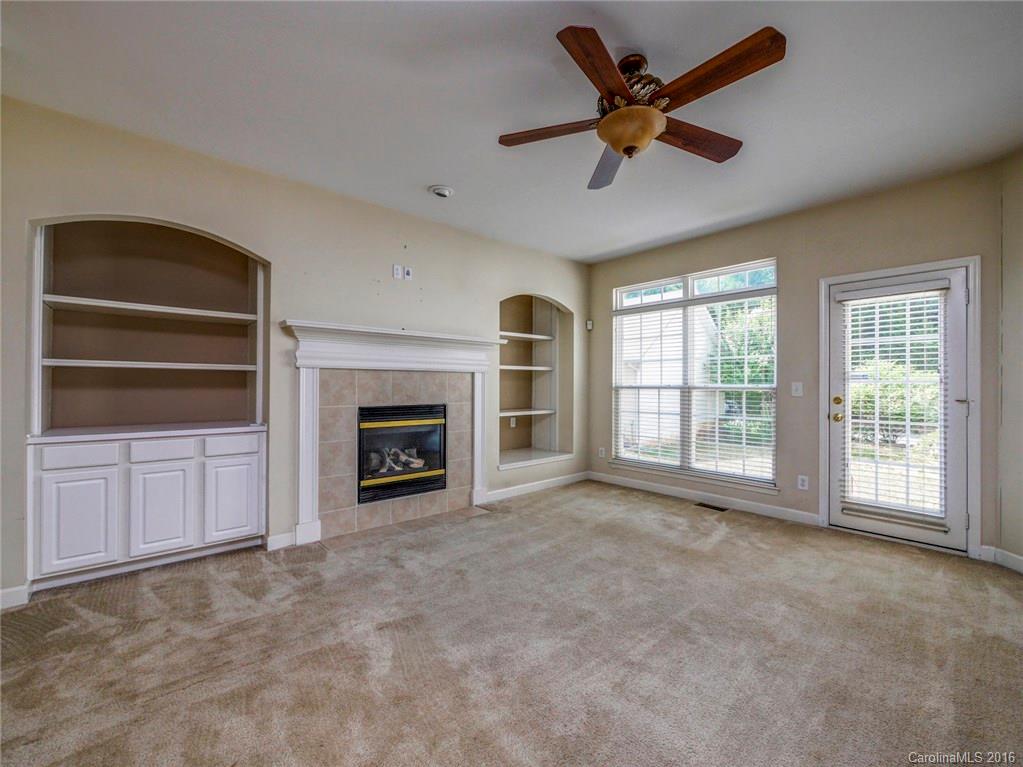 8319 Camberly Road Huntersville, NC 28078 - Photo 4 of 24 a view of an empty room with a fireplace and a window