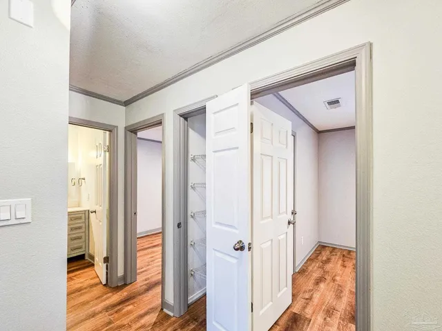 a view of a hallway with wooden floor and closet