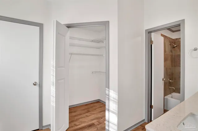 a view of a hallway with a room that has a bed