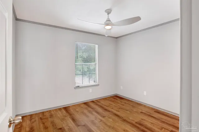 an empty room with a window and wooden floor