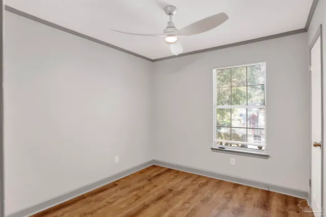 an empty room with a window and a ceiling fan