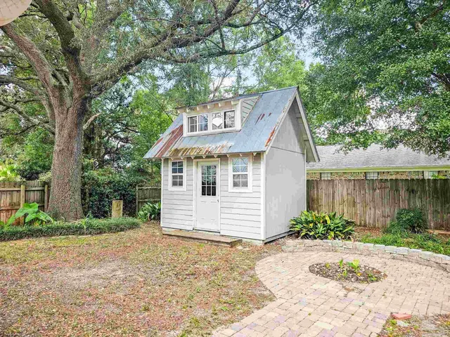 a front view of a house with a yard and lake view