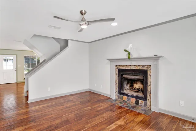 a living room with wooden floor and a fireplace