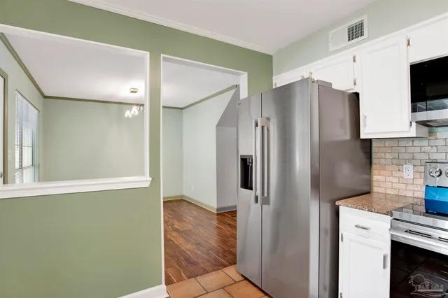 a kitchen with stainless steel appliances granite countertop a refrigerator and a stove top oven
