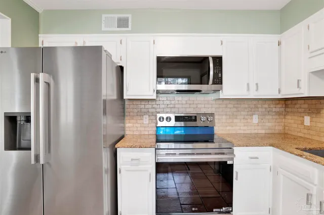 a kitchen with stainless steel appliances a stove microwave and refrigerator