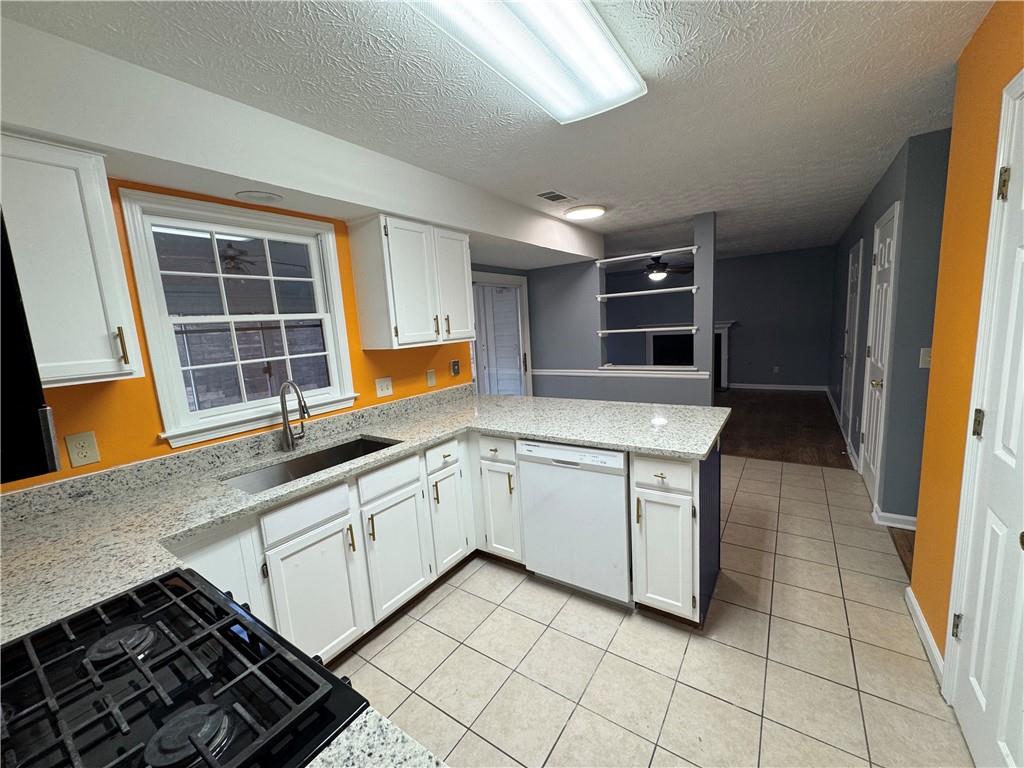 3205 Ivy Station Drive Duluth, GA 30096 - Photo 12 of 38 a kitchen with granite countertop a stove sink and cabinets