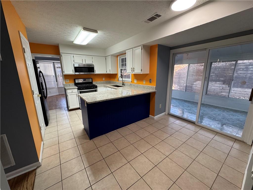 3205 Ivy Station Drive Duluth, GA 30096 - Photo 3 of 38 a kitchen with stainless steel appliances a sink stove and cabinets