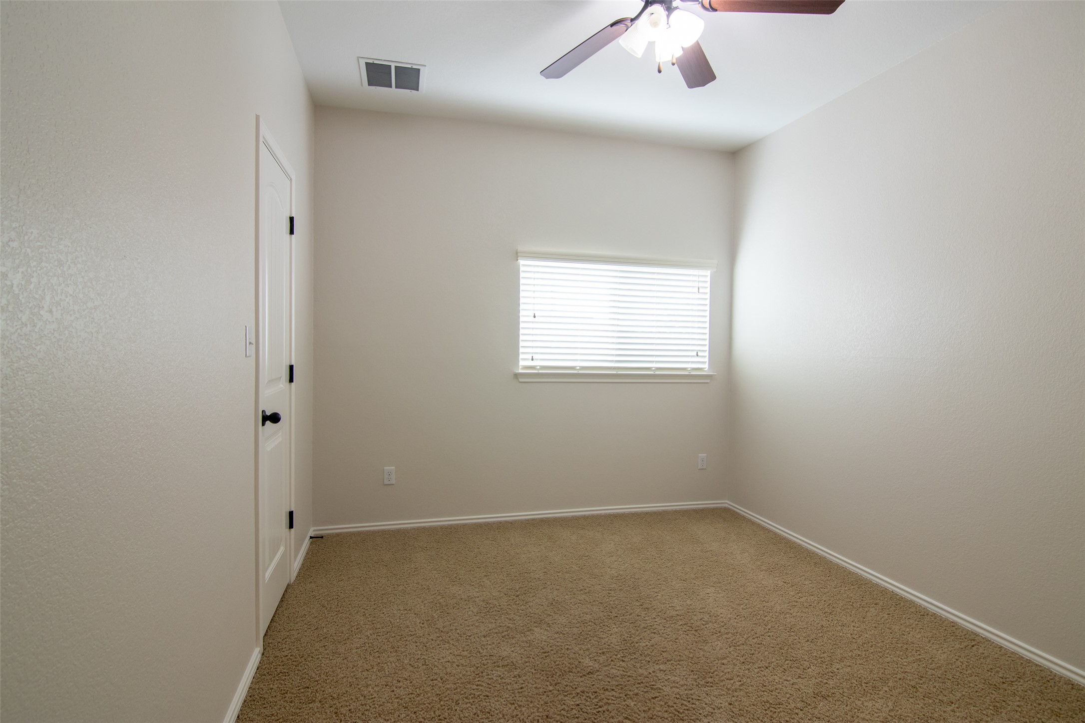 12104 Broten Street Austin, TX 78748 - Photo 26 of 32 A comfortable bedroom with plush carpeting and a modern ceiling fan, offering a serene personal space.