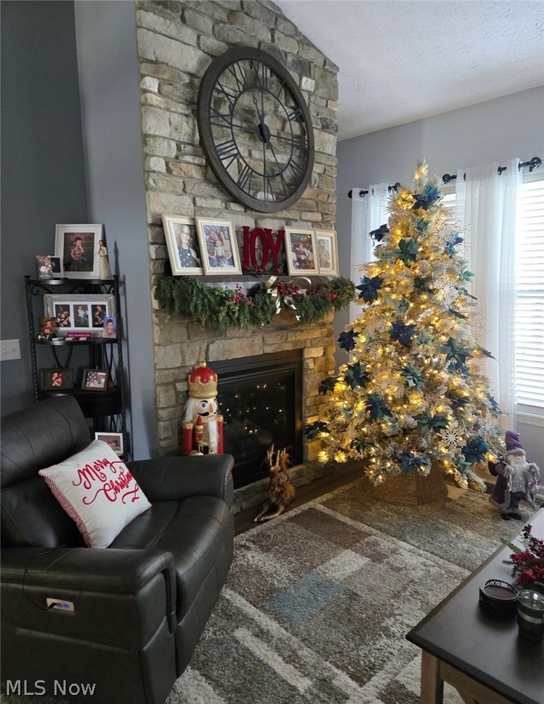 109 West Spring Drive Elyria, OH 44035 - Photo 9 of 46 Stone fireplace with a dark metal clock feature, gas insert, and a white mantel