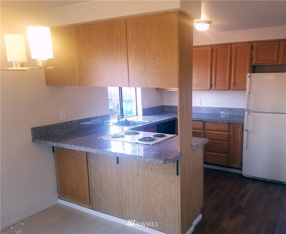 303 Houser Way South Renton, WA 98057 - Photo 14 of 19 a kitchen with kitchen island cabinets and wooden floor