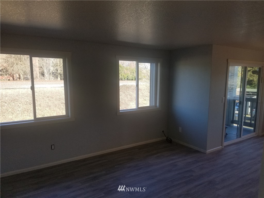 303 Houser Way South Renton, WA 98057 - Photo 8 of 19 an empty room with wooden floor and windows