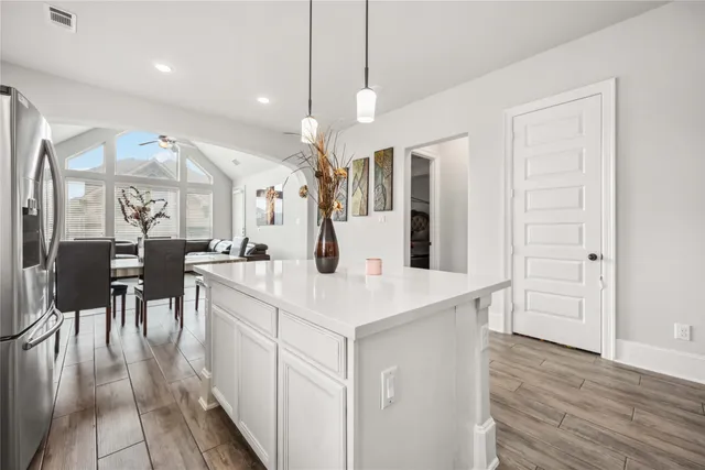 a large white kitchen with lots of counter space and painting on the wall