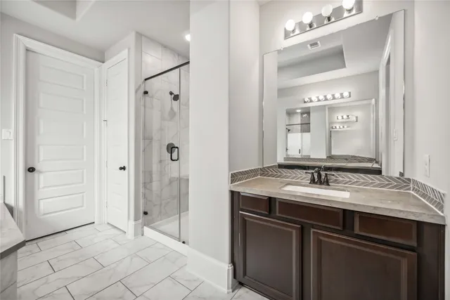 a spacious bathroom with a granite countertop sink mirror and shower