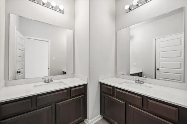 a bathroom with double sink and a mirror