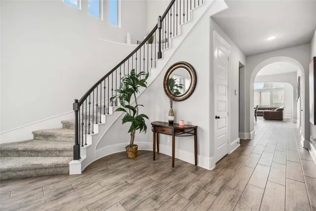 a view of a hallway with wooden floor and front door