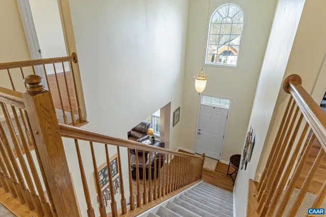 a view of staircase with railing and a book shelf