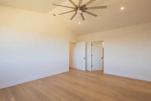 a view of a room with wooden floor and a ceiling fan