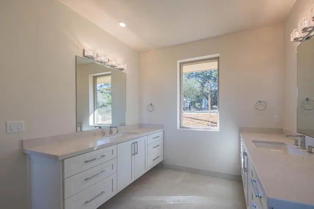 a bathroom with a sink mirror and a window