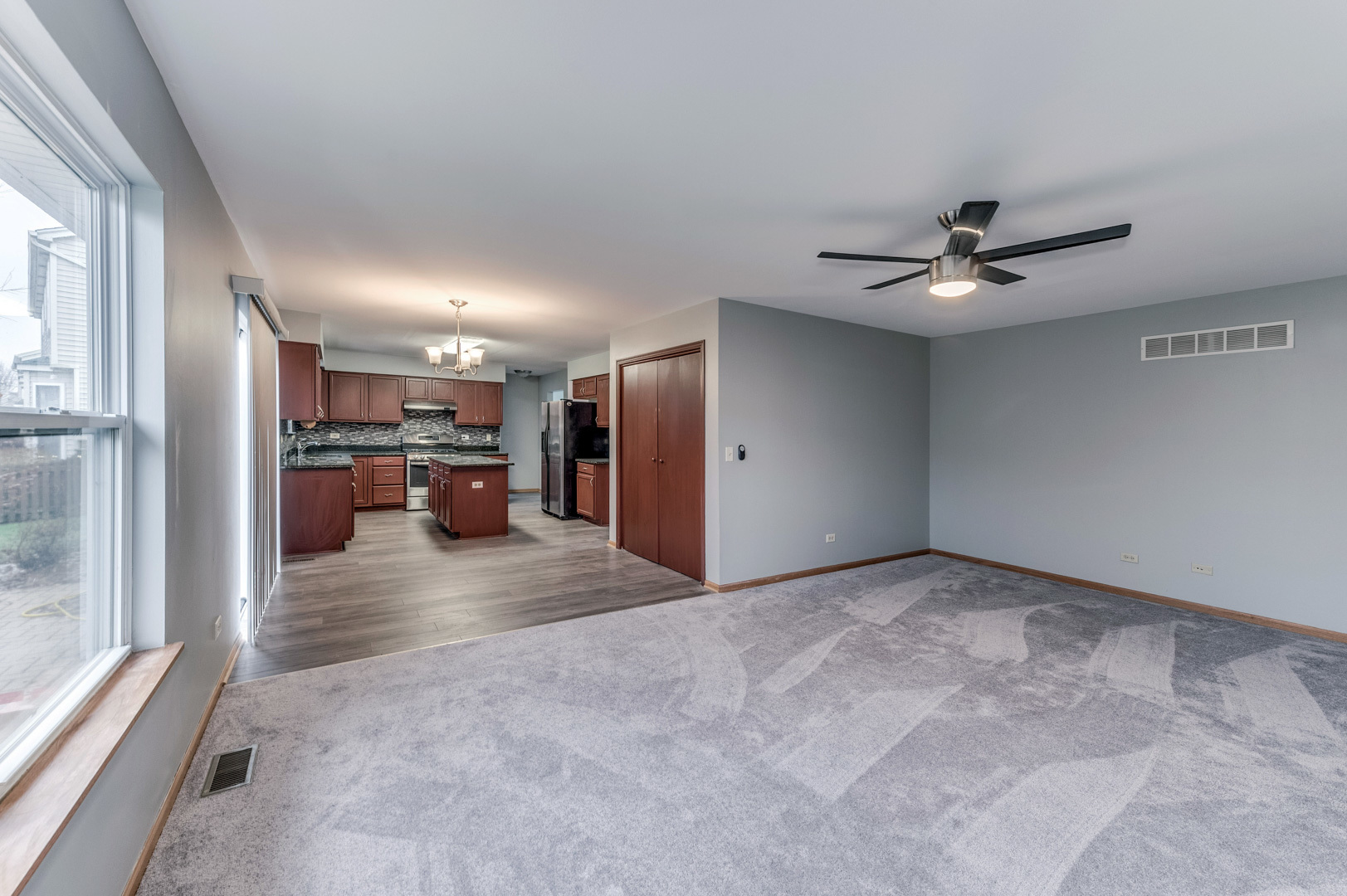 1809 Lake Shore Drive Romeoville, IL 60446 - Photo 14 of 30 a view of a livingroom with a kitchen space a ceiling fan a kitchen view and a window