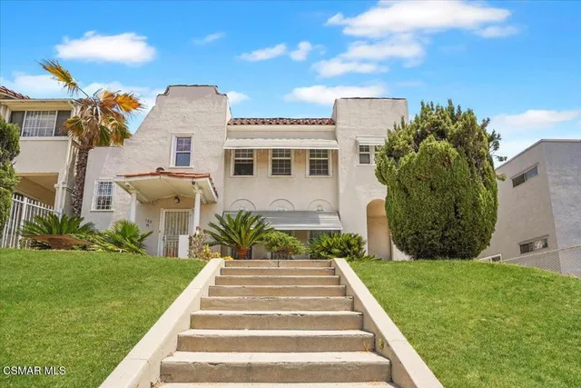 a front view of a house with a garden and yard