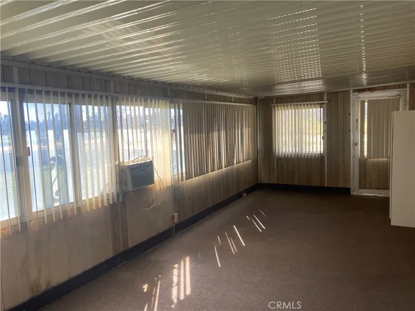 a view of an empty room with large windows