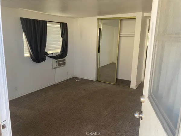 a view of a small space with wooden floor and a window