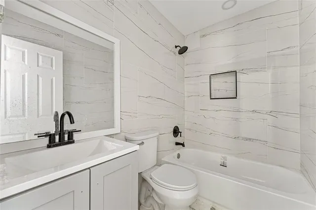 a bathroom with a sink a toilet and bathtub