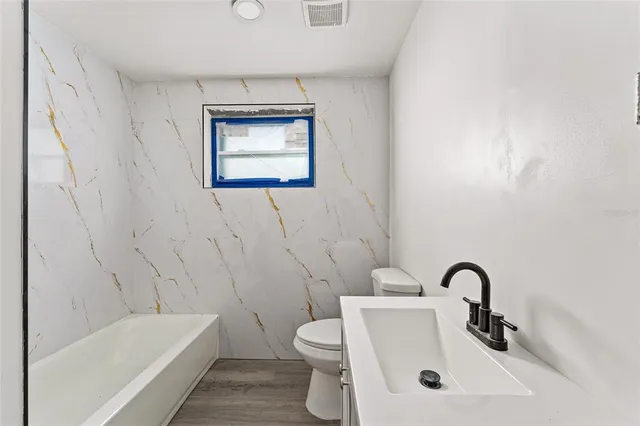 a bathroom with a sink a toilet and bathtub