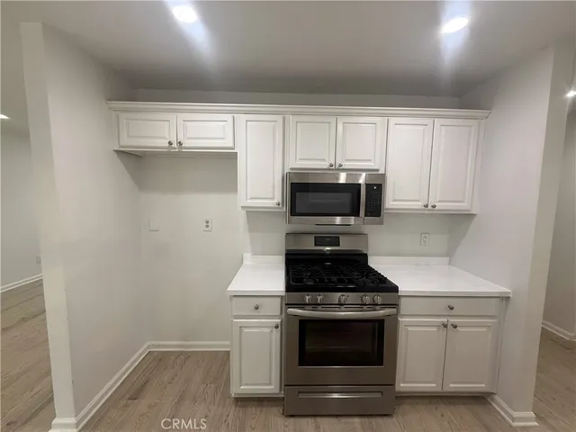 a kitchen with white cabinets and stainless steel appliances