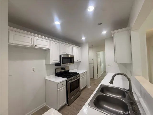 a kitchen that has a sink and a stove top oven