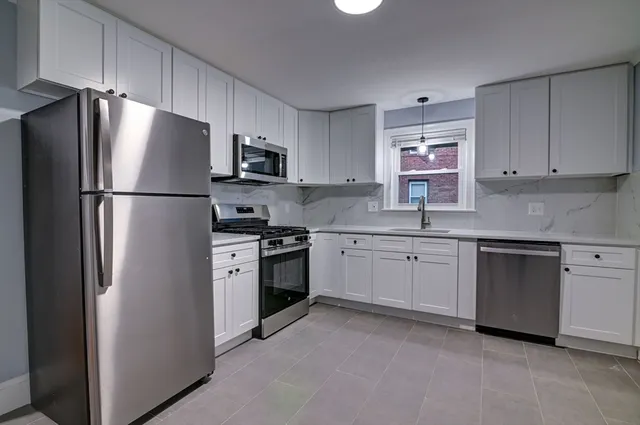 a kitchen with stainless steel appliances granite countertop a refrigerator sink and stove