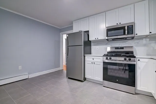 a kitchen with stainless steel appliances white cabinets and a stove top oven