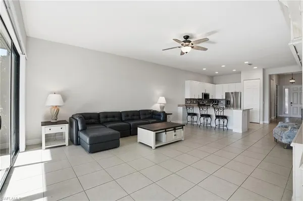 a living room with furniture and a dining table with kitchen view