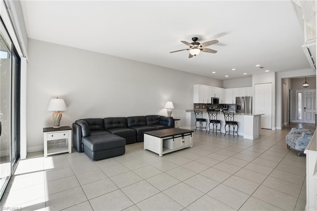 4194 Amelia Way Naples, FL 34119 - Photo 14 of 44 a living room with furniture and a dining table with kitchen view