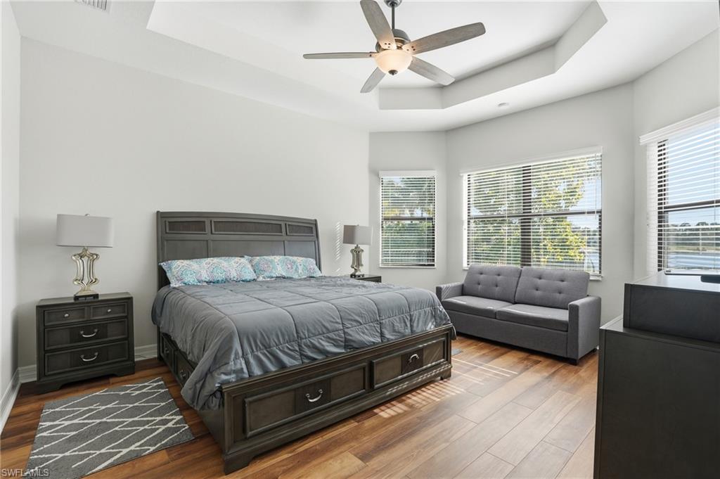 4194 Amelia Way Naples, FL 34119 - Photo 19 of 44 a bedroom with a bed a couch and a window