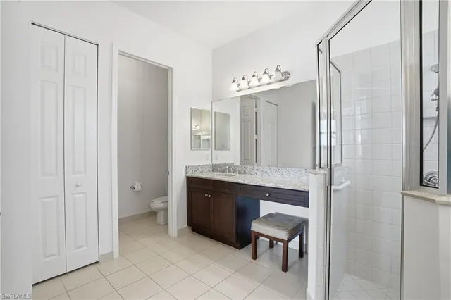 a spacious bathroom with a granite countertop sink a mirror and a bathtub