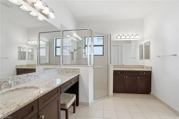 a bathroom with a granite countertop sink a mirror and shower