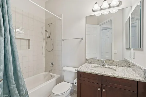 a bathroom with a granite countertop sink a toilet and shower